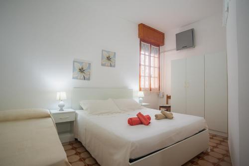 ein Schlafzimmer mit einem weißen Bett mit zwei ausgestopften Tieren in der Unterkunft Casa Arianna, apartment a few steps from the sea in Marina di Mancaversa
