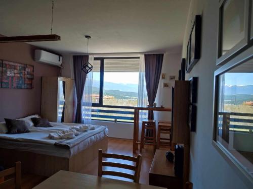 a bedroom with a bed and a large window at F307 Studio Aspen Golf Resort Bansko in Bansko