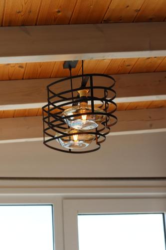 a black metal chandelier hanging from a ceiling at ARXONTIKO in Himare