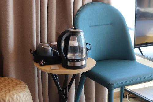 a tea kettle sitting on a table next to a chair at ARXONTIKO in Himare