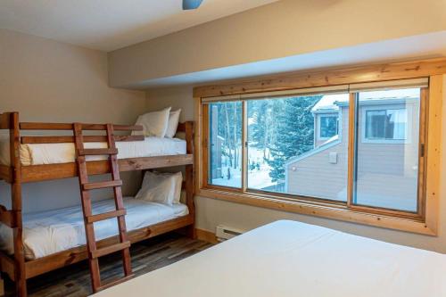 a bedroom with two bunk beds and a window at Walk to Skiing Hiking and Main Street in Breckenridge
