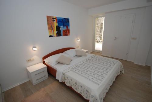 a white bedroom with a bed and a window at Wenn Sie in der Nähe des Strandes sein wollen, sind Sie dort in Zaostrog