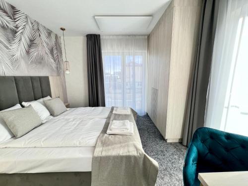 a bedroom with a large bed with a bench on it at SILVER BALTIC in Kołobrzeg