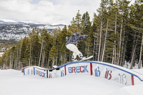 a man riding a snowboard on a rail in the snow at Cozy 2BR Condo Near Peak 8 and Town with Hot Tub Access in Breckenridge