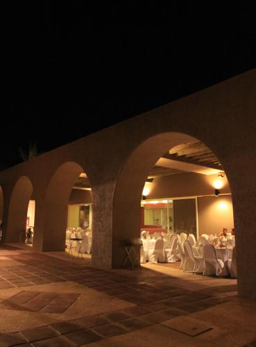 an outdoor patio with white chairs and tables at night at Loreto Bay Golf & Sea at Baja in Loreto