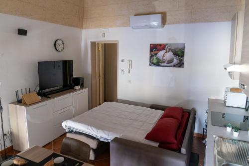 a small bedroom with a bed and a tv at San Lorenzo House in Andria