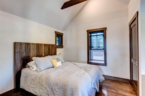 ein Schlafzimmer mit einem Bett mit einem hölzernen Kopfteil in der Unterkunft Aurum Condo - 1 BR with Mtn Views, Steps from Main St in Breckenridge