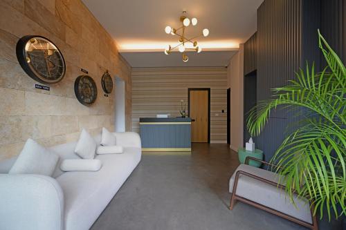 sala de estar con sofá blanco y planta en Comfy apart hotel en Beirut