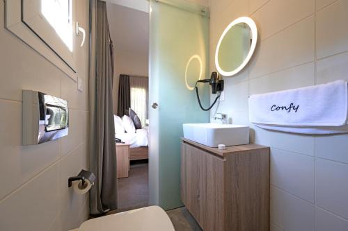 uma casa de banho com um WC, um lavatório e um espelho. em Comfy apart hotel em Beirute