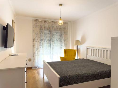1 dormitorio con 1 cama y 1 silla amarilla en Luxury Apartments in Expo en Lisboa
