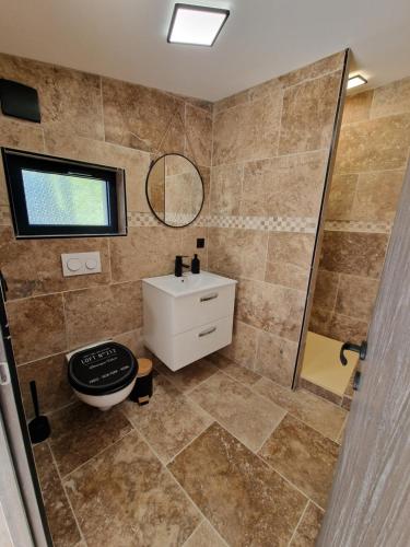 ein Bad mit einem Waschbecken und einem Spiegel in der Unterkunft au petit îlet in Fos-sur-Mer