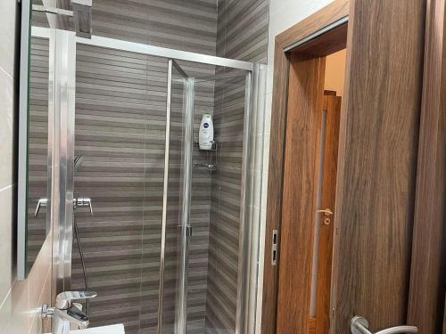 een douche met een glazen deur in de badkamer bij 74 temple point 3 bedroom APT in Marsaxlokk
