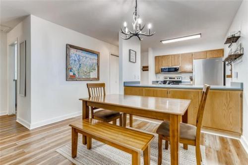 a kitchen and dining room with a wooden table and chairs at Lovely 2 BDR Condo Close to Skiing and Main St in Breckenridge