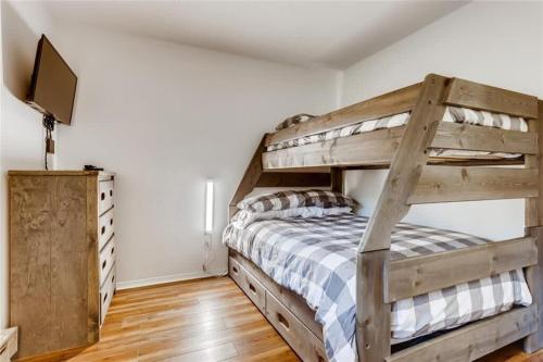 a bedroom with a wooden bunk bed and a television at Lovely 2 BDR Condo Close to Skiing and Main St in Breckenridge