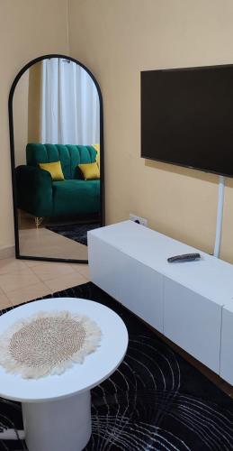 uma sala de estar com um sofá e um espelho em COMFORT CORNER em Juja