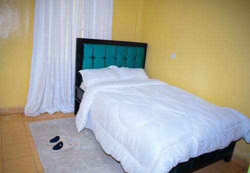 a bedroom with a large white bed and a window at COMFORT CORNER in Juja