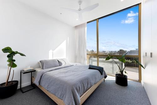a bedroom with a bed and a large window at Soho Penthouse - Luxury lifestyle property in Prahran in Melbourne