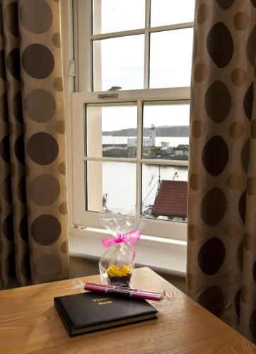 a table with a plate of food and a window at Harbourside Apartments with Private Parking in Scarborough
