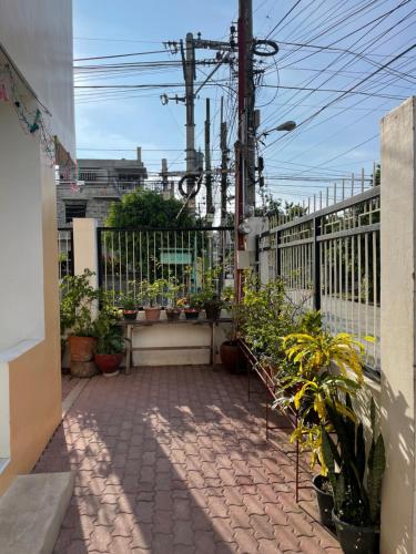 a patio with potted plants and a fence at Chan One Corner in San Juan