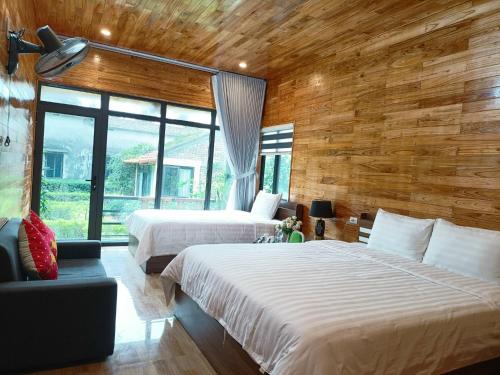 a bedroom with two beds and a large window at Tam Coc Sunshine Homestay in Ninh Binh
