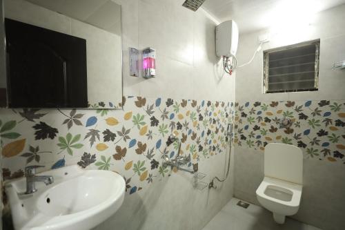 a bathroom with a sink and a toilet at Sundarbagh farmhouse in Khamshet
