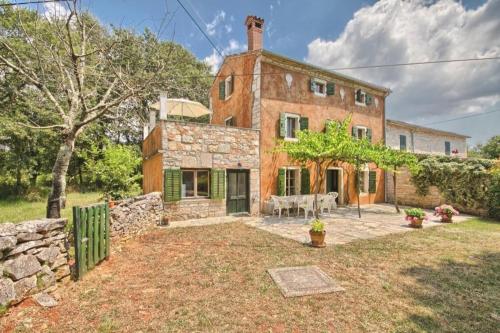 an old brick house with a table in the yard at Ferienhaus mit Privatpool für 8 Personen ca 150 qm in Červari, Istrien Westküste von Istrien in Kanfanar