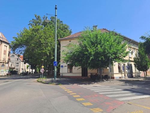 a building on a street with a crosswalk at Andi Apartment Szeged Center in Szeged
