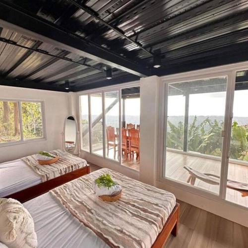 sypialnia z 2 łóżkami i dużym oknem w obiekcie Veronica Guesthouse w/ Breathtaking Mountain View w mieście Bagolig