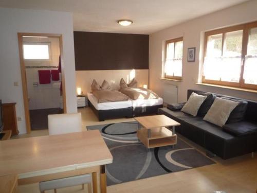 ein Wohnzimmer mit einem Bett und einem Sofa in der Unterkunft Ferienwohnung für 2 Personen ca 32 m in Würzburg, Bayern Franken in Würzburg