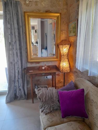 a living room with a couch and a mirror at Jenny's Greek Villa in Levktron