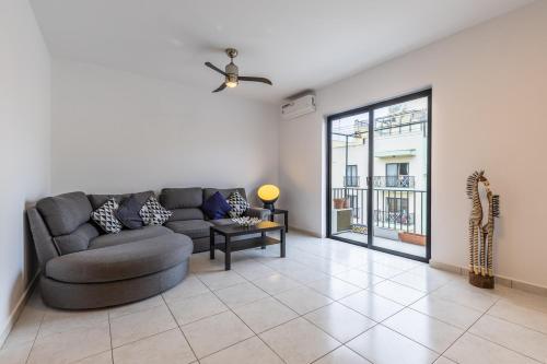 a living room with a couch and a window at Home walking distance from the sea. in St Paul's Bay