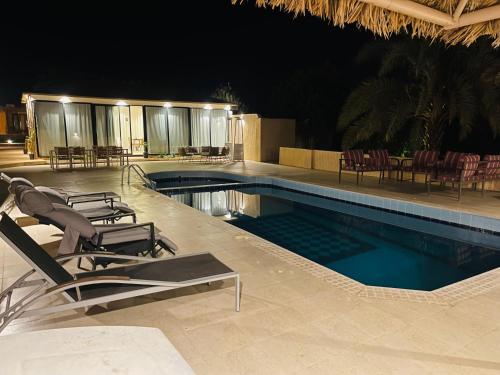 a swimming pool with lounge chairs and a resort at سيال 1 in AlUla