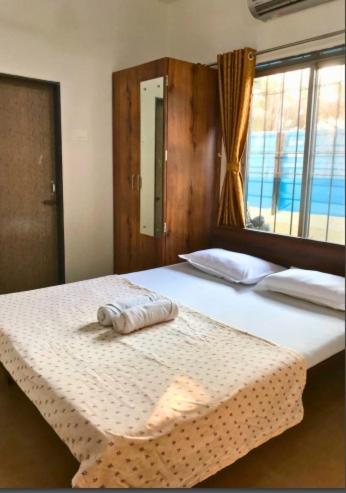 ein Schlafzimmer mit einem Bett und einem Handtuch darauf in der Unterkunft Classic Villa 3BHK Villa in Chondi Alibag in Alībāg