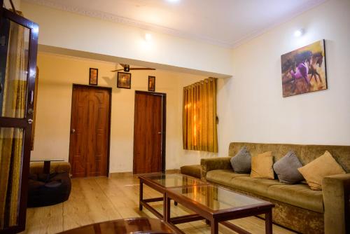 ein Wohnzimmer mit einem Sofa und einem Tisch in der Unterkunft Classic Villa 3BHK Villa in Chondi Alibag in Alībāg