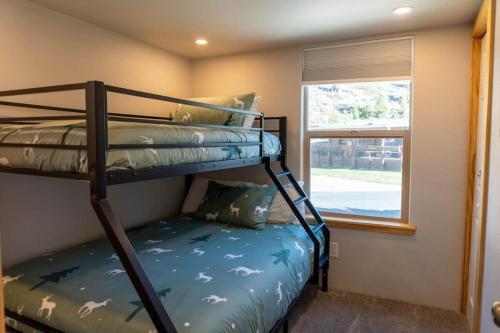 a bunk bed in a room with a window at 2BR Riverside Cabin Near Trails with Hot Tub Access in Breckenridge