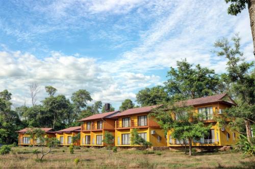 a row of houses in a field with trees at River Park International Resort in Chitwan