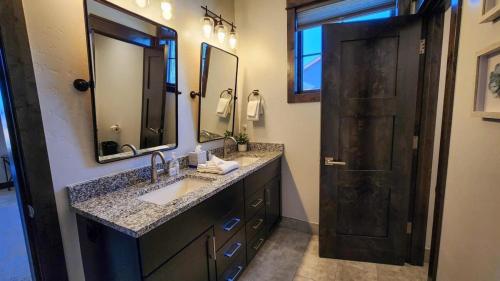ブリッケンリッジにあるLuxurious 4BR with Hot Tub and Stunning Mountain Viewsの洗面台と鏡とドアのあるバスルーム