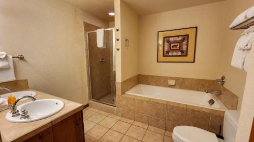 a bathroom with a sink and a tub and a toilet at Main St Station Condo with Hot Tub and Parking in Breckenridge