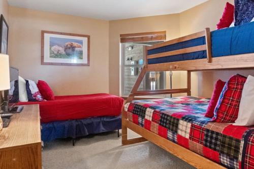 a bedroom with two bunk beds and a desk at Cozy Ski In Ski Out Walk to Main St in Breckenridge