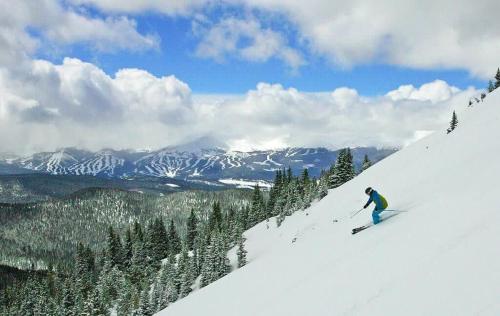 a man is skiing down a snow covered mountain at Cozy Ski In Ski Out Walk to Main St in Breckenridge