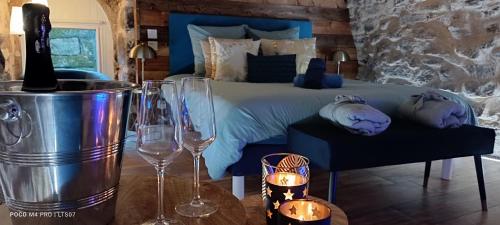 a bedroom with a bed with two wine glasses at Le Temps Suspendu in Saint-Pierreville