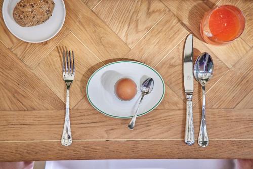 a table topped with a plate with an egg and silverware at Palazzo Vecchio Taormina in Taormina