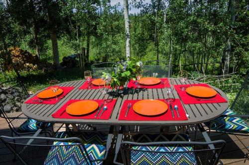 a table with orange plates on it on a patio at Cozy 2BR with Great Views Near Trails in Silverthorne