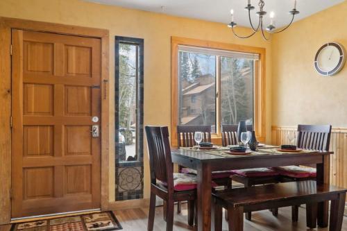 a dining room with a table and chairs and a door at Cozy 2BR with Great Views Near Trails in Silverthorne