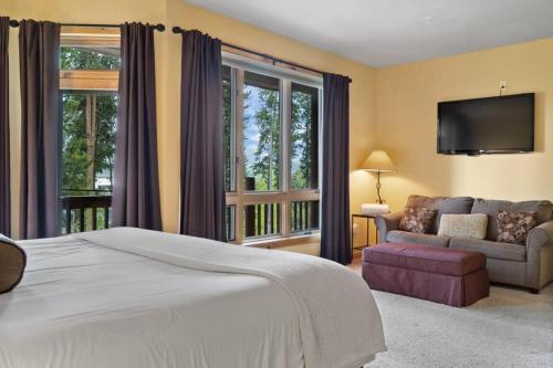 1 dormitorio con cama, sofá y TV en 4BDR Ski in Ski Out by Snowflake Lift, en Blue River