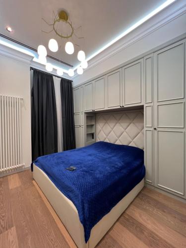 a bedroom with a large bed with a blue blanket at ARP_apartments in Baku