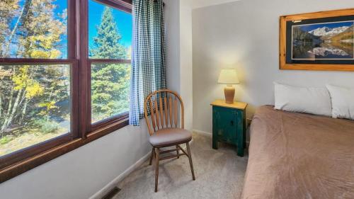a bedroom with a bed and a chair and a window at 1BR Rustic Retreat Near Trails and Slopes in Dillon