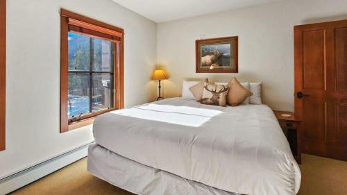 a bedroom with a large white bed and a window at Cozy 2BD Near Free Shuttle and Ski Lifts in Dillon