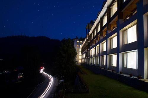 a building at night with lights on a street w obiekcie The Ananda Kufri, Shimla w mieście Kufri