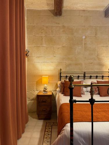 a bedroom with two beds and a lamp on a table at Maria's B&B in Għasri